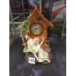 A bisque mantel clock depicting Courting Couple on bench with clock housed in a roofed folly