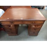 An oak pedestal writing desk with brown leatherette top. COLLECT ONLY.