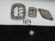 Two early 20th century belt buckles, a silver marcasite brooch and a star choker.