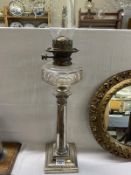 A Victorian Everard & Co silverplated column oil lamp with faceted glass font