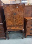 An early 20th century walnut veneered cocktail cabinet. COLLECT ONLY.