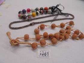 Three long coloured necklaces.