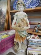 A tall early 20th century plaster figure of a girl with puppies. COLLECT ONLY.