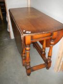 An oval oak gate leg table with barley twist supports, COLLECT ONLY.