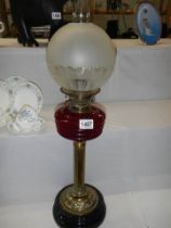 A Victorian oil lamp with ruby glass font on brass base and with original etched shade, COLLECT ONLY