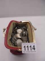 A red purse full of sixpenny coins.