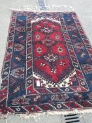 A good old rug in a blue and red pattern, 76 x 50 inches. COLLECT ONLY.