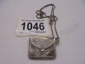A vintage silver purse on a white metal chain.