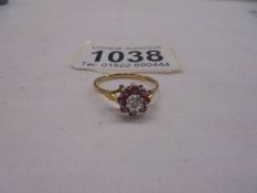 A yellow gold dark sapphire with central diamond ring, size N, 1.3 grams.