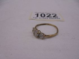 A three stone 9ct yellow gold ring, size M, 1.4 grams.