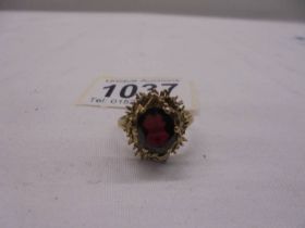 A large oval ruby/garnet? yellow gold ring, size Q half, 5 grams.