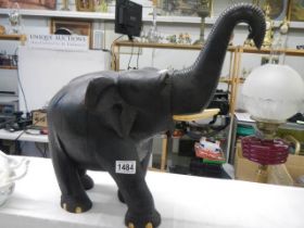 A large carved elephant with bone tusks. COLLECT ONLY.