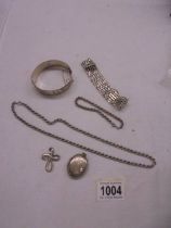 A silver bangle, silver neck chain, silver bracelet, silver locket and silver cross etc., 99 grams.