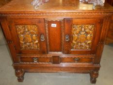 A two door cupboard with carved doors depicting coats of arms, COLLECT ONLY.