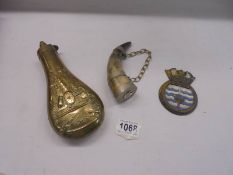 A brass powder flask, a horn wall hanging and a Bulwark plaque.