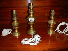 Three brass table lamp bases.