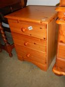 A three drawer pine bedside chest. COLLECT ONLY.