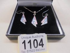 A silver pendant with matching earrings by Anne McFarlane.
