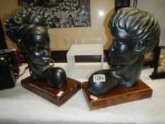 A pair of black plaster heads (one being a table lamp).