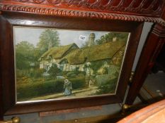 An early 20th century oak framed woolwork of a thatched cottage, COLLECT ONLY.