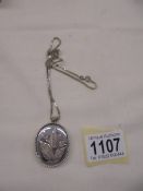 A silver locket on a silver chain,