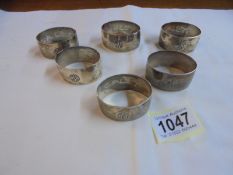 A set of six napkin rings monogrammed H S P with middle eastern scenes on reverse (possibly silver).