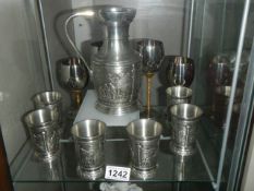 An Artina pewter jug with six beakers and four wine goblets
