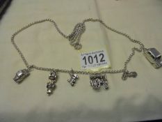 A long silver chain with six transport related charms,