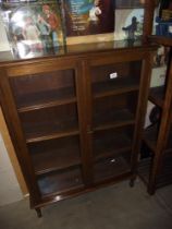 A glazed darkwood bookcase 89cm x 27cm x 122cm