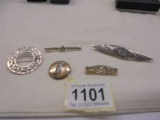 Five assorted silver brooches.