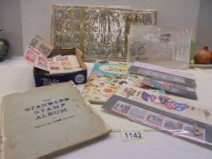 An album of stamps, loose stamps and an empty stamp album.