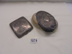 A silver cigarette case and a scrap piece of silver from a brush back.