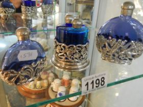 A pair of blue glass perfume bottles in stand and two other blue glass perfume bottles.
