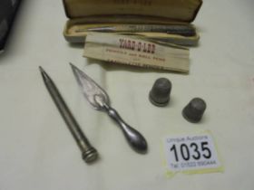 A silver 'Yard O' Lead' pencil, another silver pencil, a silver bookmark and two silver thimbles.