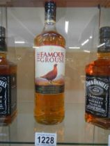 A sealed one litre bottle of The Famous Grouse whisky.