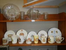 A mixed lot of commemorative china and glass ware on two shelves, COLLECT ONLY.