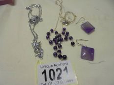 A silver and bead necklace, a pair of silver and purple stone earrings and a white metal owl