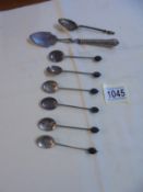 Six silver coffee bean spoons, a silver handled sugar spoon and an unmarked spoon.