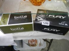 A boxed pair of Ballistic Fury glasses and a boxed pair of Bolle' tactical glasses.