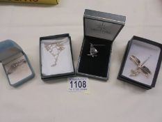 A silver dragonfly pendant, a silver windsurfer pendant, a silver rabbit pendant & a silver brooch.