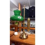 A brass student lamp with green glass shade