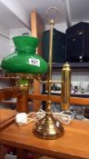 A brass student lamp with green glass shade