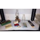 A mixed lot including oil lamp with chimneys, boxed harmonica, watches, RAF tie pin etc