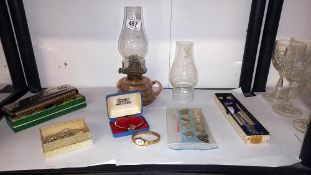 A mixed lot including oil lamp with chimneys, boxed harmonica, watches, RAF tie pin etc