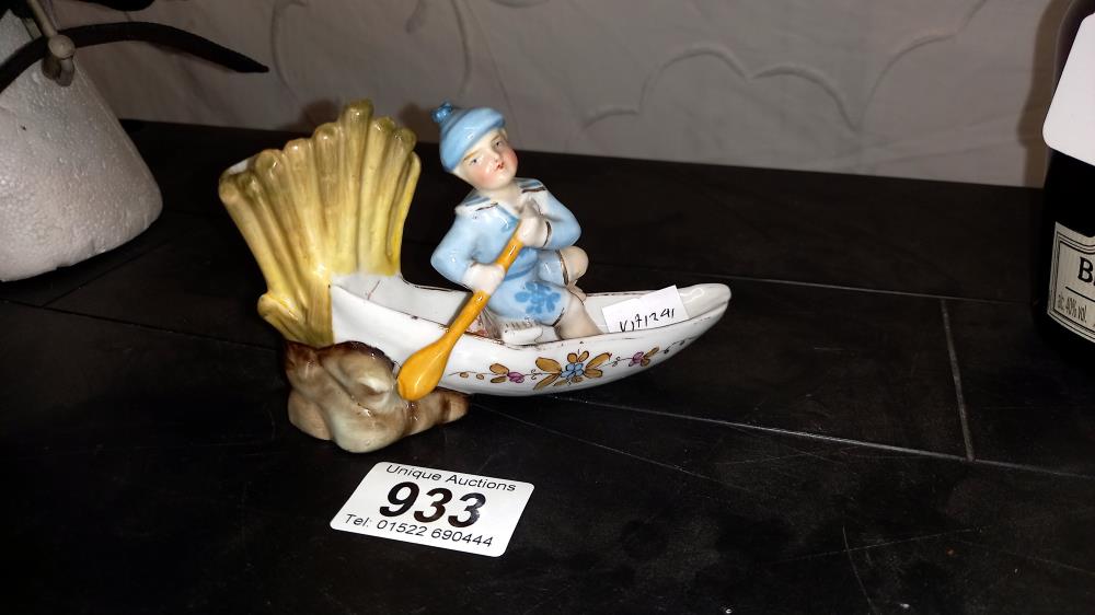 A continental glazed bisque match striker of a boy in a rowing boat