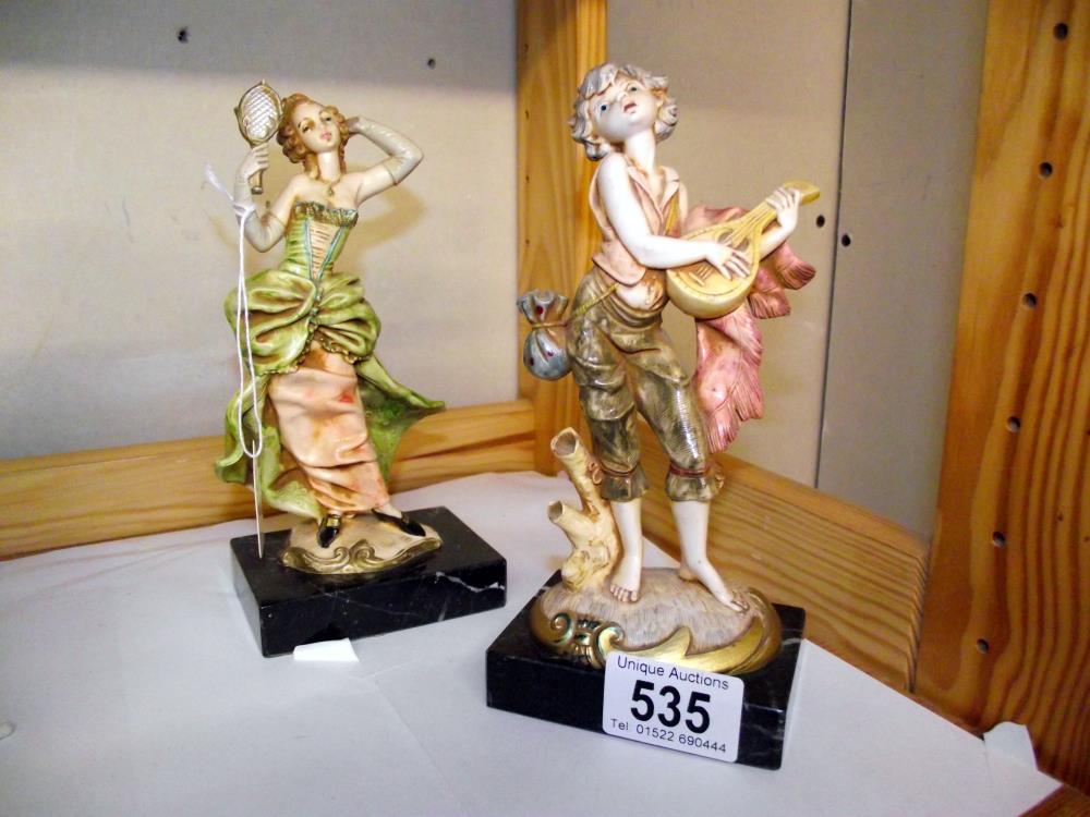 A pair of Italian figures on Carrera marble bases