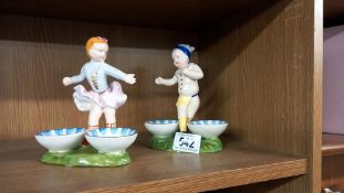 A pair of continental glazed bisque entree dishes with figures