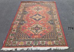 A red patterned rug, 86" x 59" COLLECT ONLY