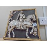 A wall plaque featuring a knight on horse back.