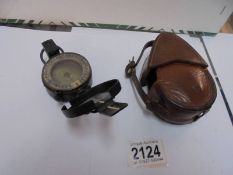 A leather cased military compass.